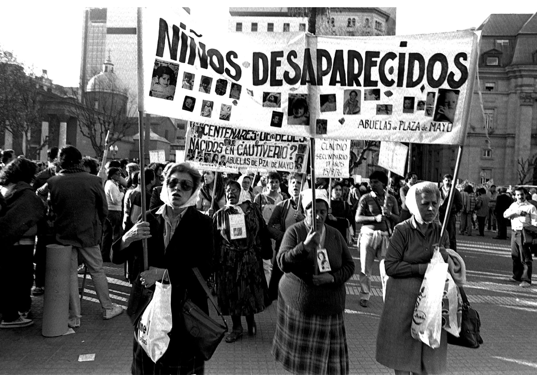 Las abuelas de Plaza de Mayo manifestándose con una bandera que dice 